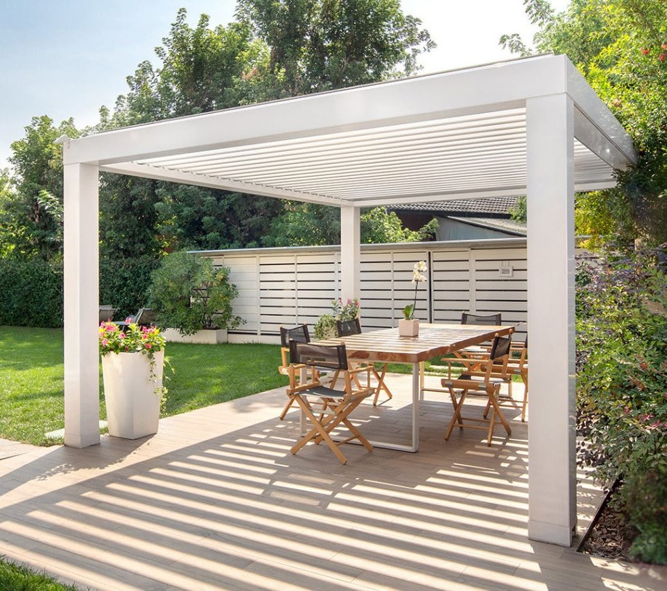 Espace repas sous une pergola bioclimatique autoportante blanche à Montjean-sur-Loire, sur terrasse dalles.