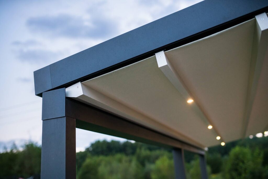 Détail d'une pergola à toile rétractable avec éclairage LED intégré.