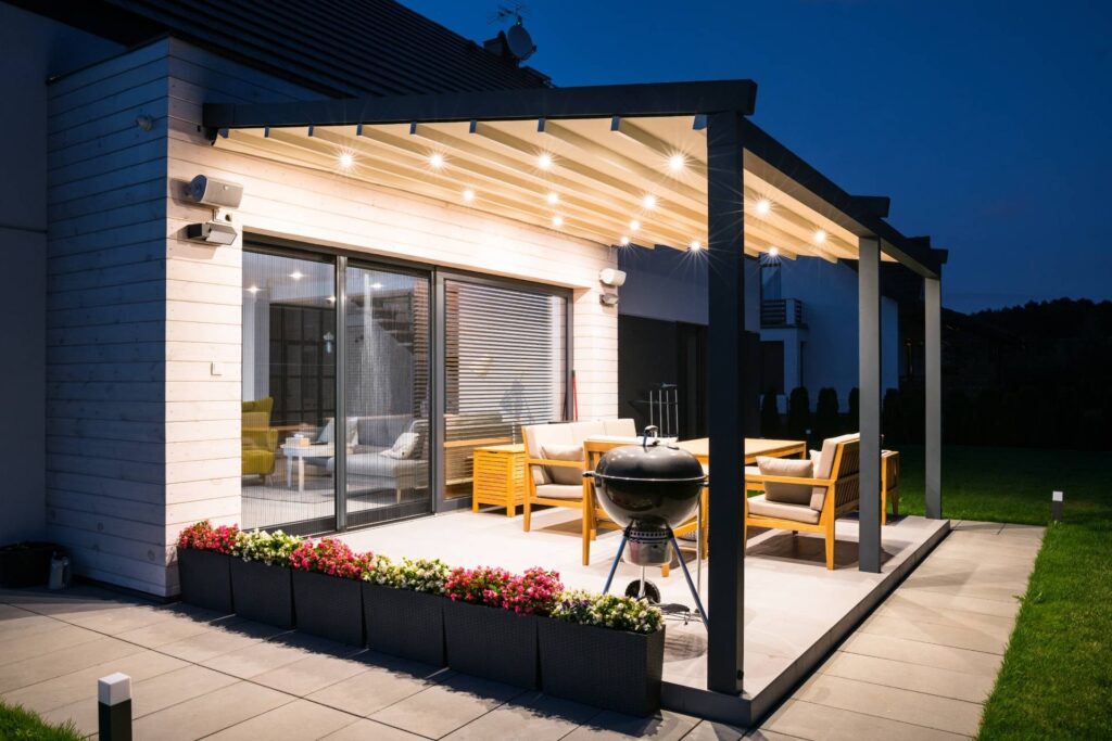 Pergola à toile rétractable installée sur une terrasse moderne à Segré, éclairée par des LED intégrées.