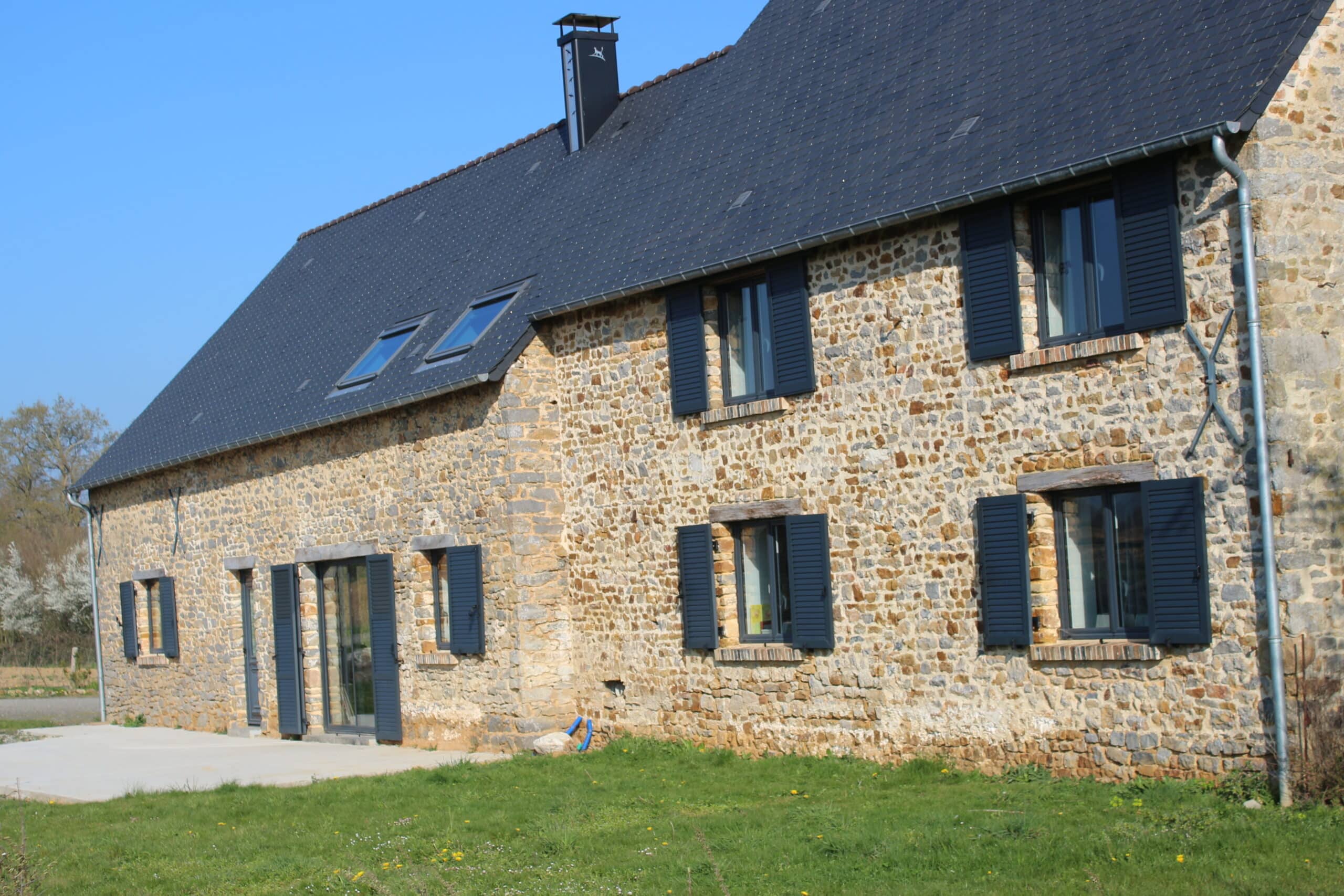 Volets battants aluminium sur une maison en pierre à Chazé-sur-Argos.