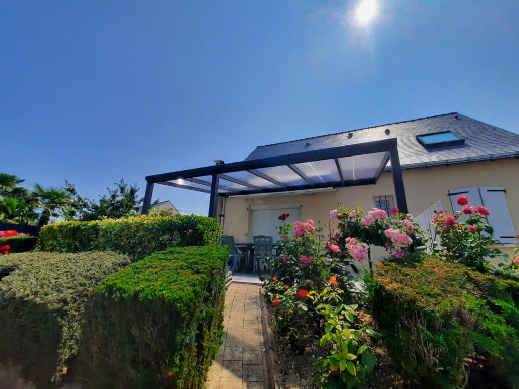 Pergola à Saumur sur terrasse entourée de fleurs.