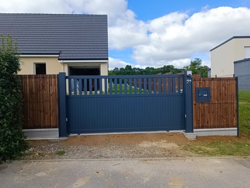 Portail coulissant aluminium avec lames verticales mi-ajourées installé près d’Angers