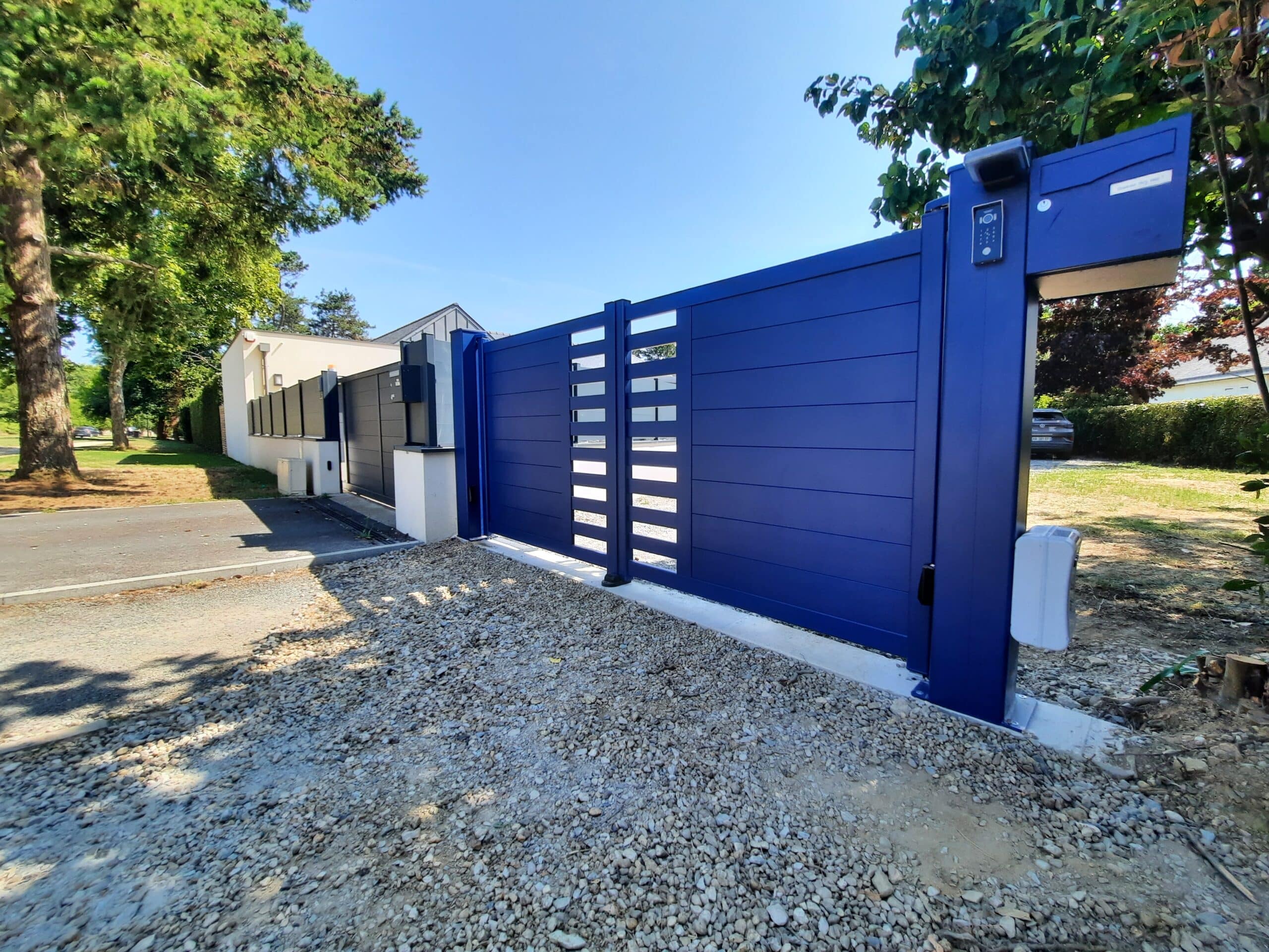 Portail battant aluminium bleu RAL 5003 à Avrillé vu de l’extérieur.