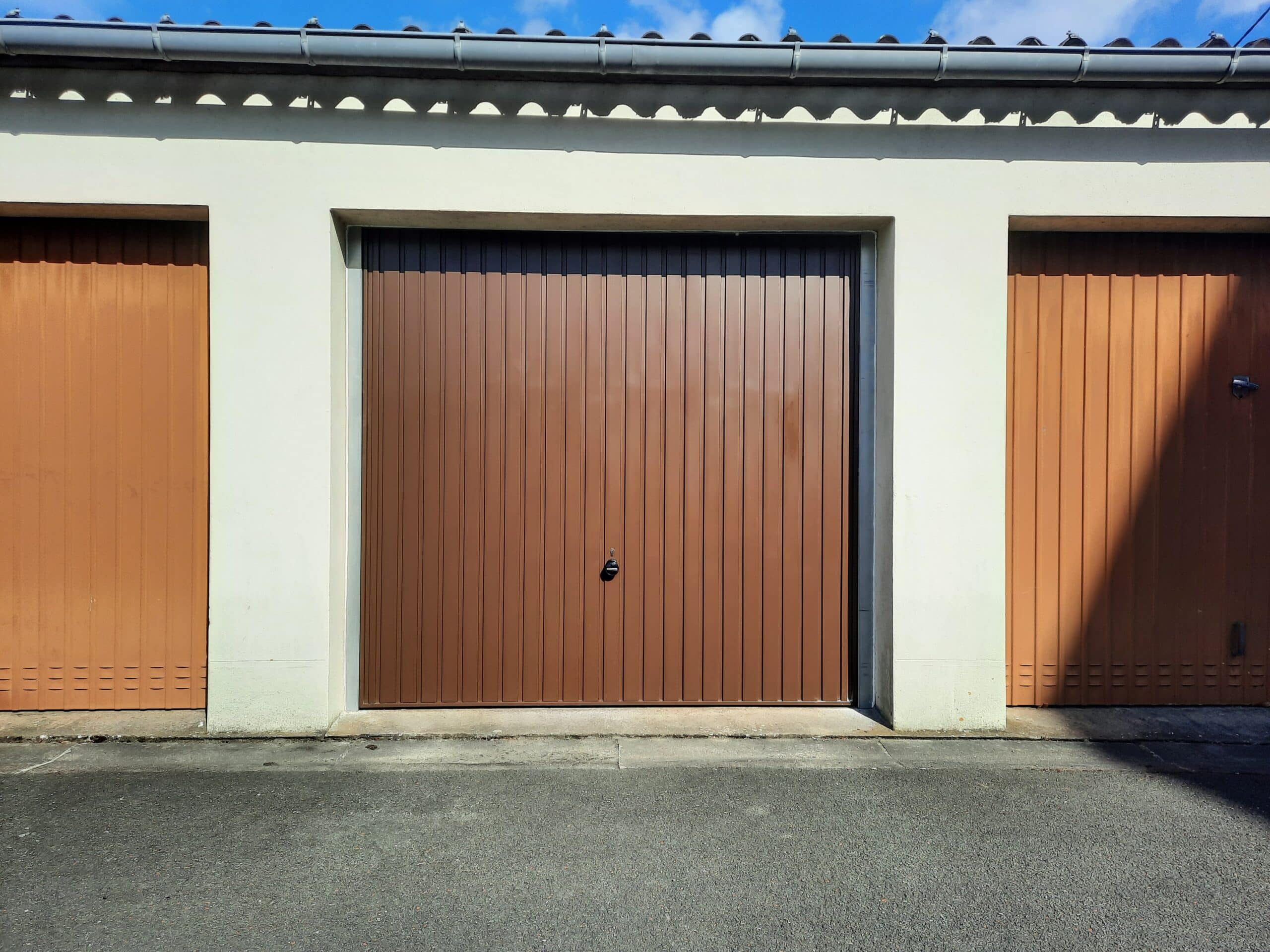 Installation d’une porte de garage basculante en acier brun à Angers.