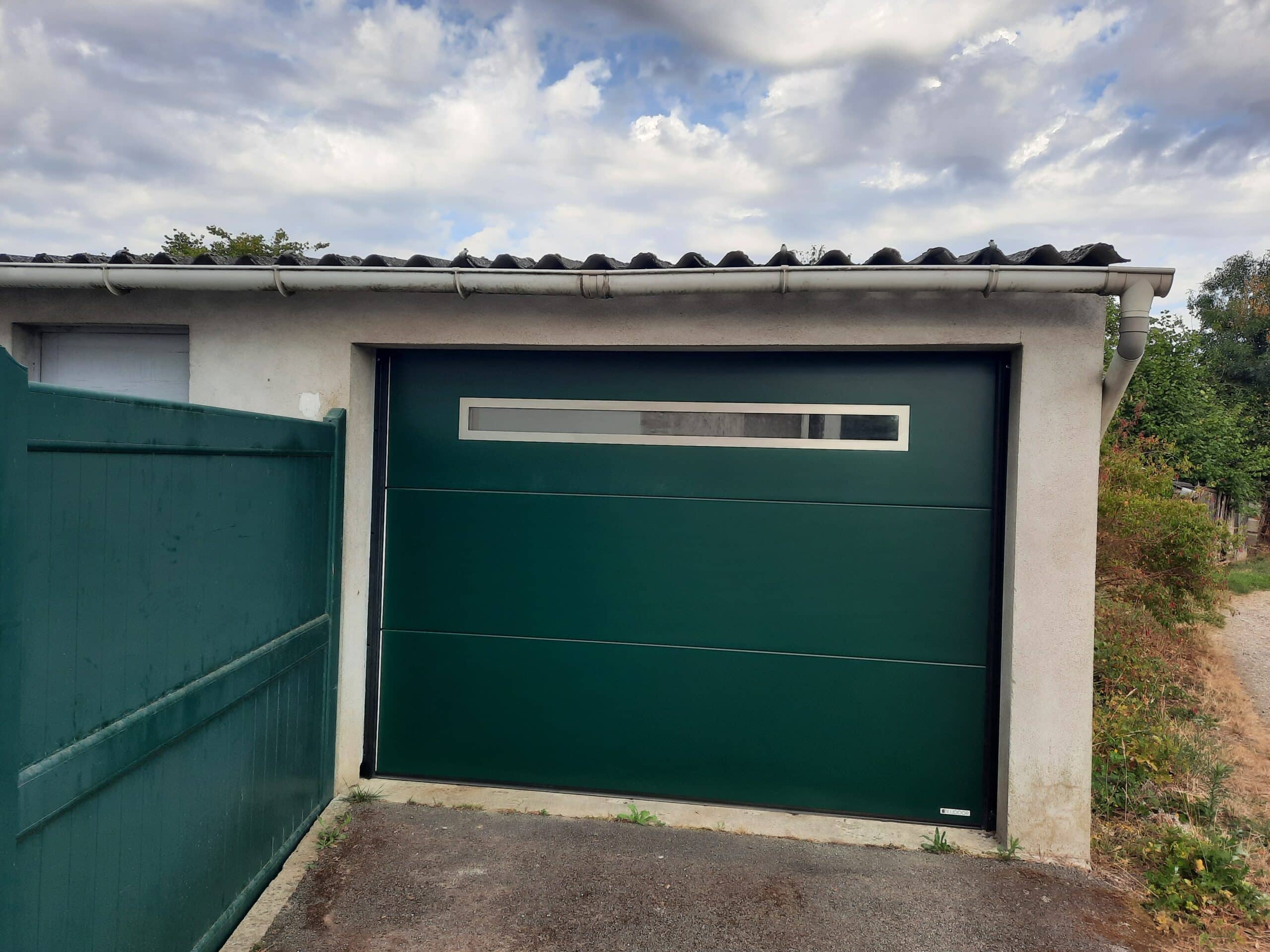 Porte de garage sectionnelle motorisée en acier vert avec hublot panoramique à Le Pin
