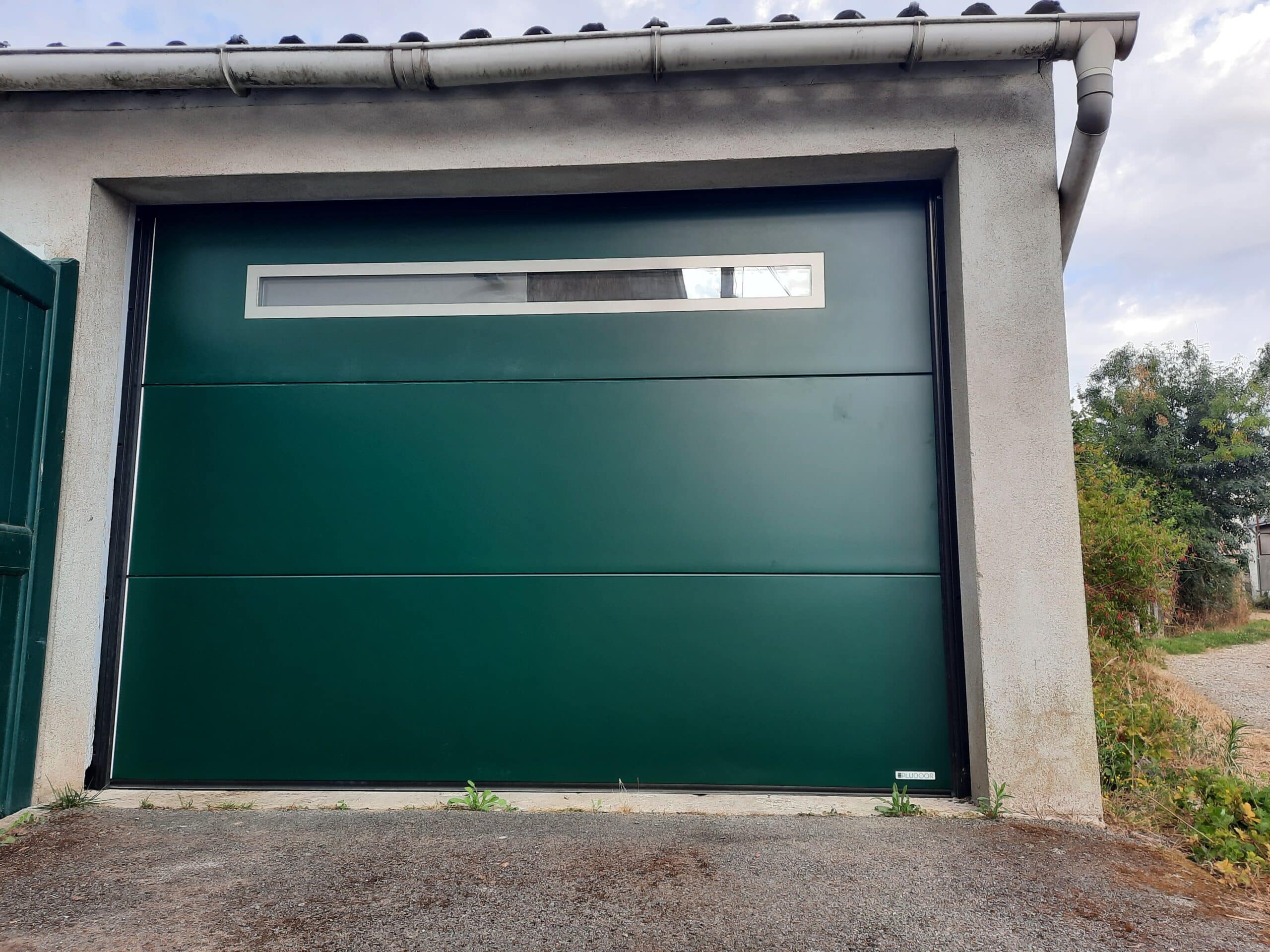 Porte de garage sectionnelle plafond motorisée avec hublot panoramique à Le Pin.