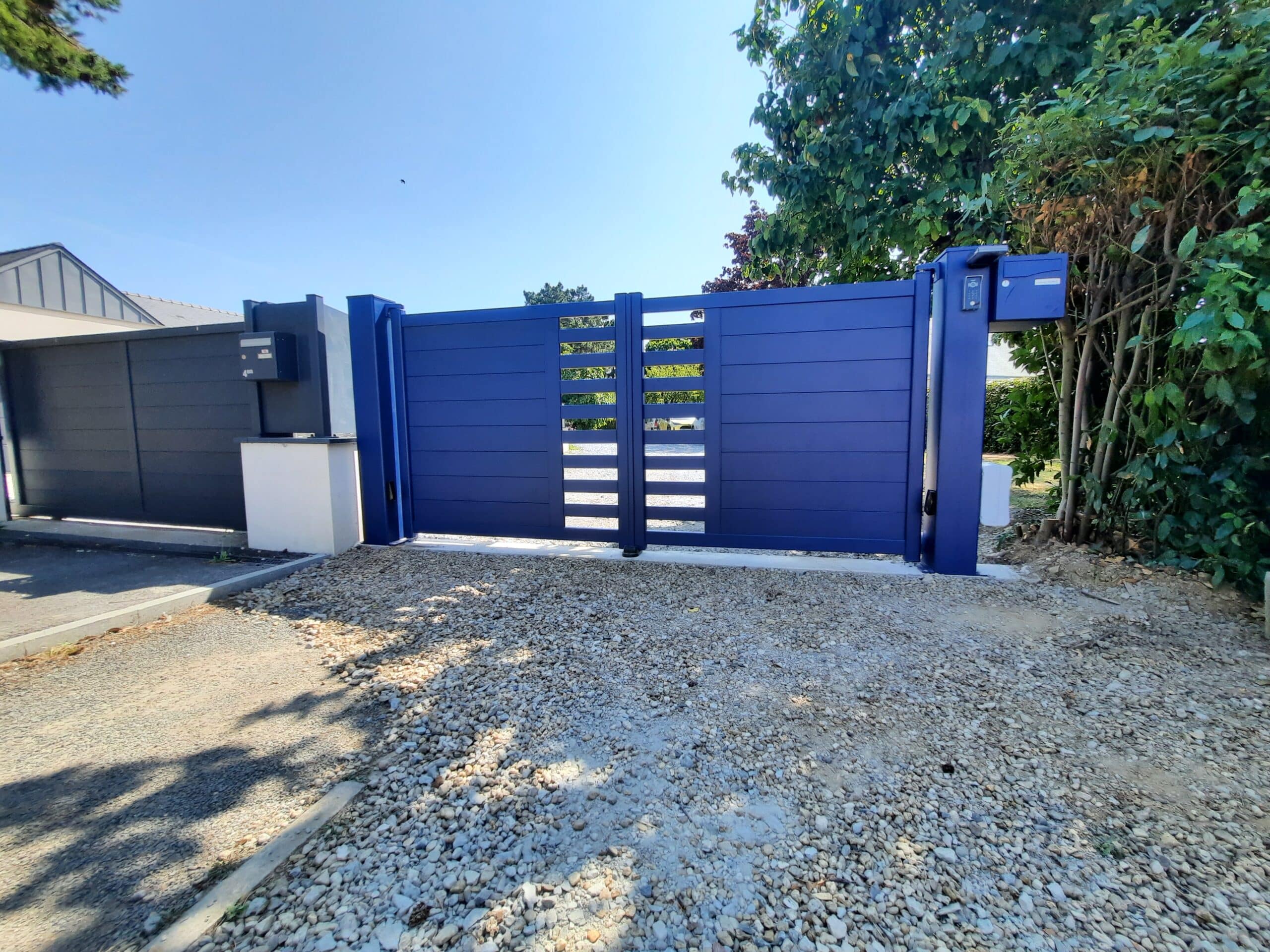 Portail battant aluminium bleu RAL 5003 à Avrillé vu de l’extérieur.