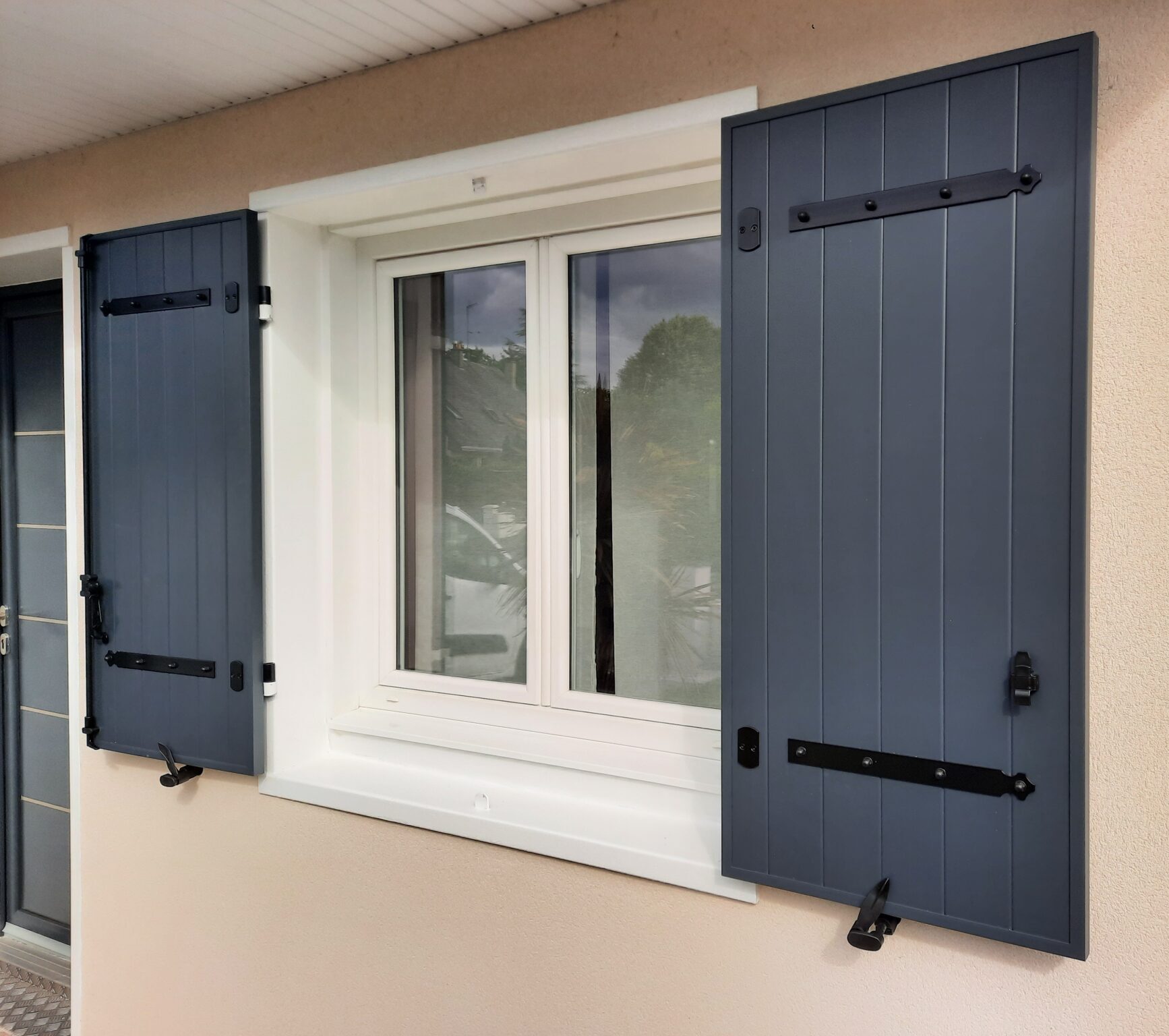 Fenetre PVC sur la façade avant d'une maison à Bouchemaine avec volets battants gris PVC ouverts