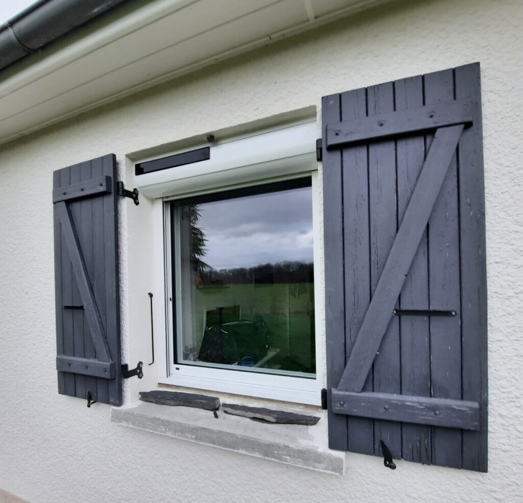 Fenêtre mixte alu/pvc avec volets roulants et moustiquaire intégrée vue de l'extérieur
