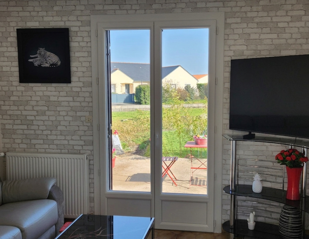 Porte-fenêtre en PVC dans le salon de la maison à Montilliers
