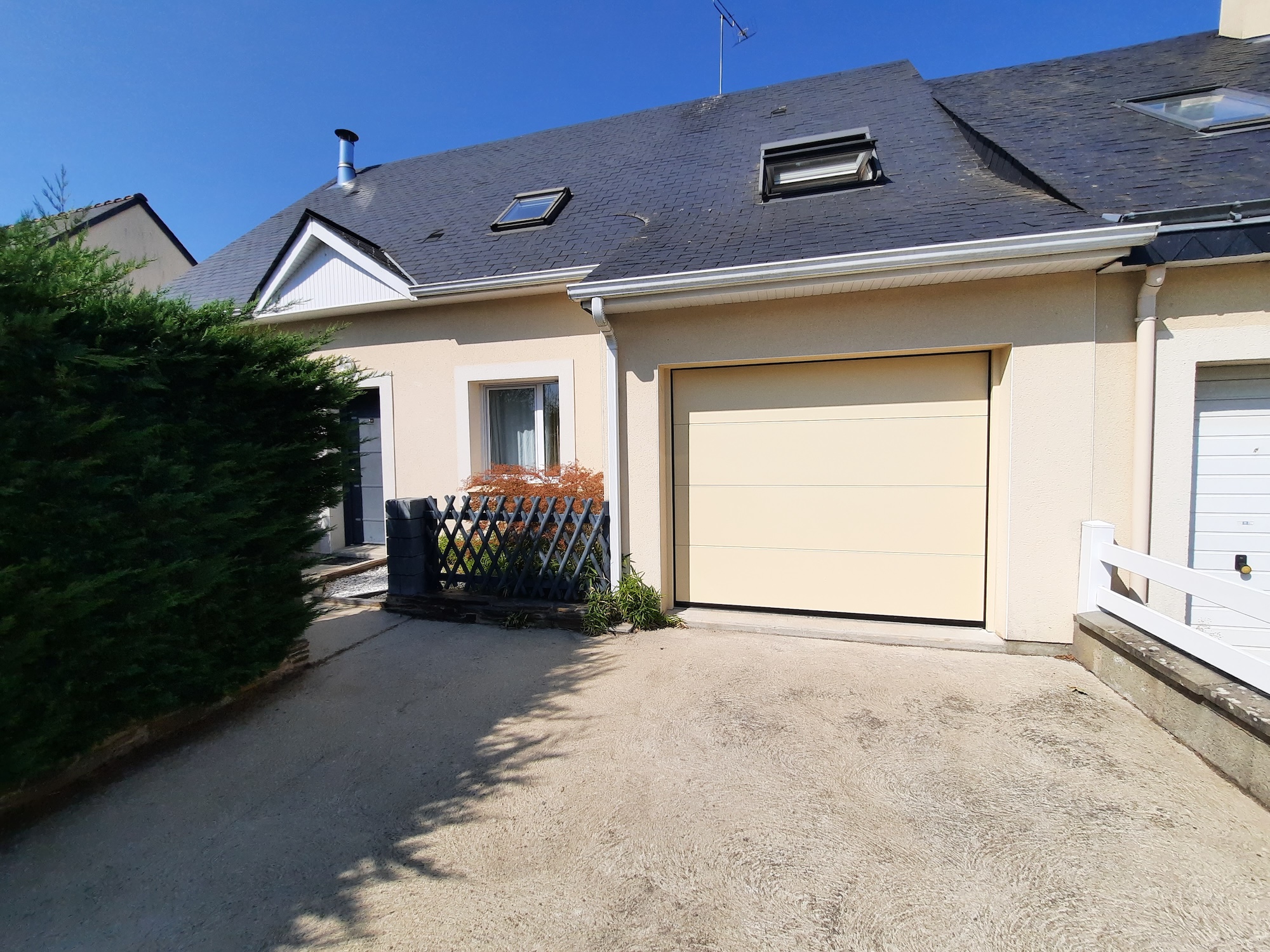 la porte de garage sectionnelle beige s'intègre parfaitement à la façade de cette maison à Trélazé, Maine-et-Loire